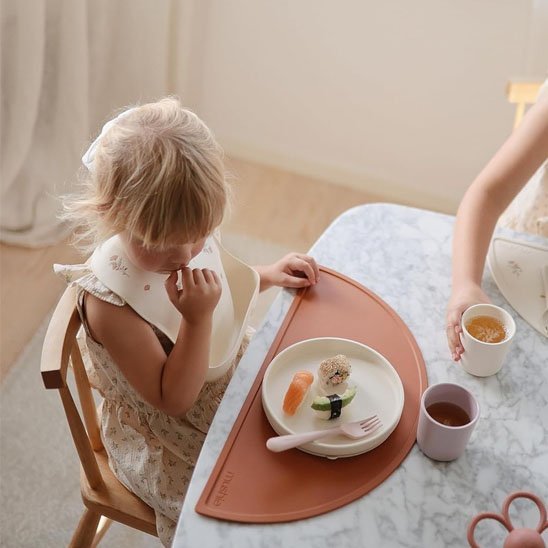 Assiette bébé  avec verre sur table