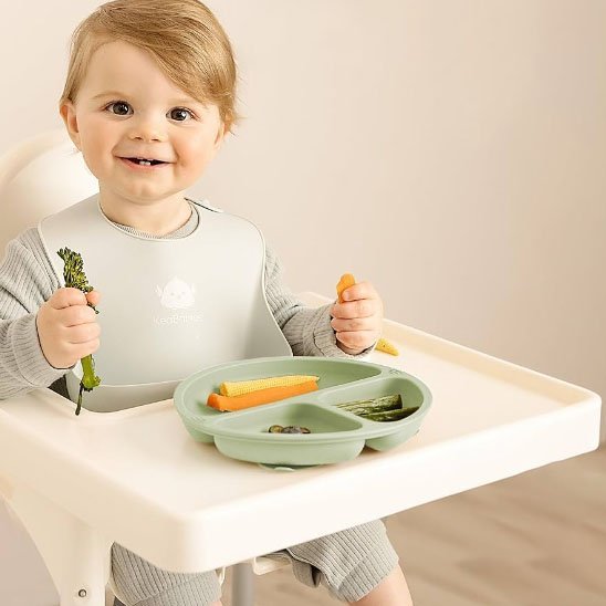 Assiette bébé vert  sur chaise haute