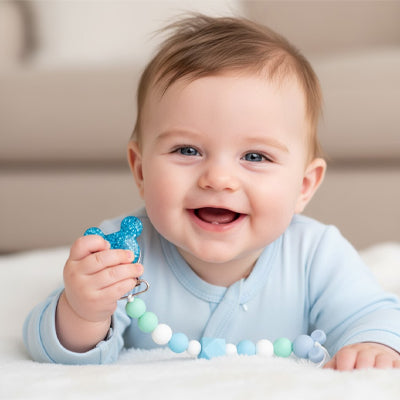 attache tetine main bebe souriant