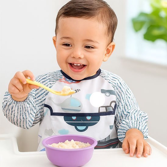 Bavoir bébé et bébé mange avec cuillère 