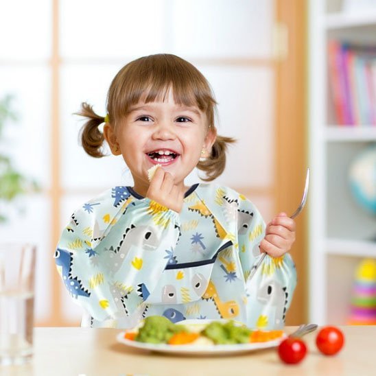 Bavoir manche longue avec une fille qui mange