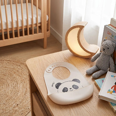 bavoir récupérateur  avec motif panda sur une table de chevet