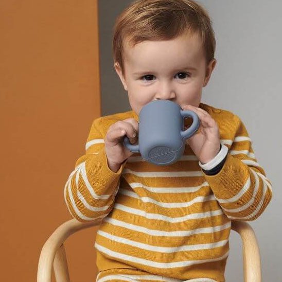 Bébé boit avec un verre bébé