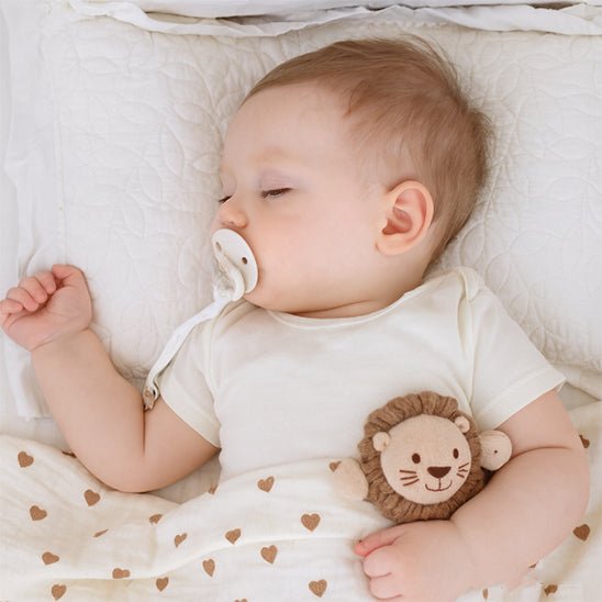 bebe dorme avec tétine dans la bouche avec attache tetine