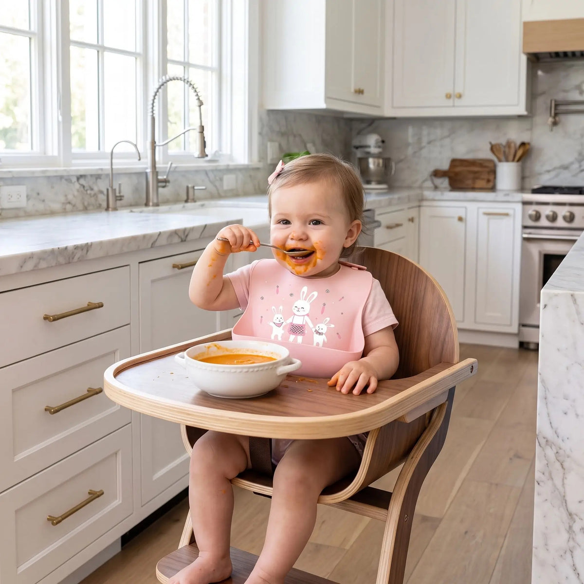 Bébé fille porte un bavoir récupérateur avec motif lapin rose