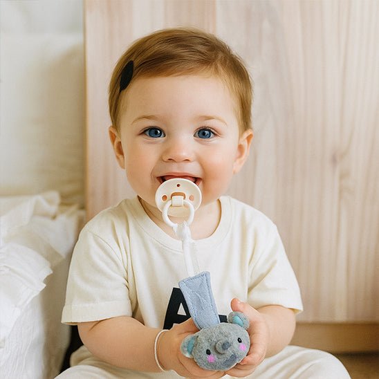 bebe heureux avec attache tetine et tétine dans la bouche 