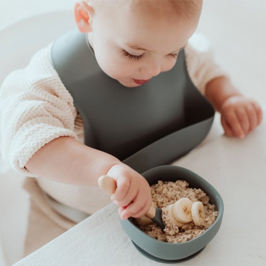bébé mange avec bavoir bébé et cuillère 