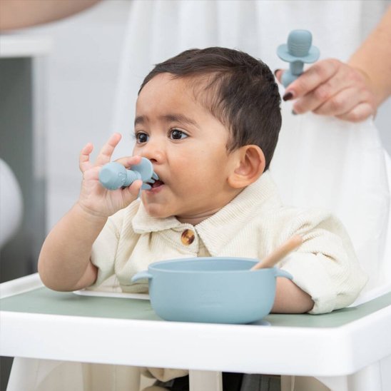 Bébé mange avec couvert bébé bleu