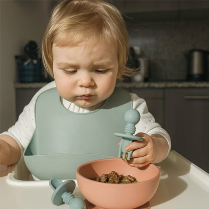 Bébé mange avec couvert bébé vert