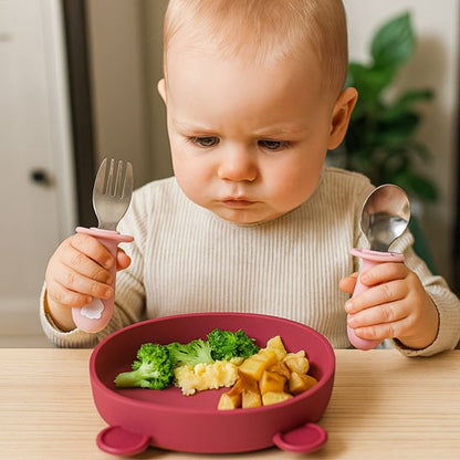 Bébé mange avec couvert pour bébé rose une patate
