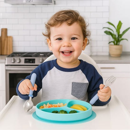 Bébé mange avec couvert sbébé​ bleu en souriant