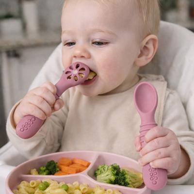 Bébé mange avec couverts bébé rose