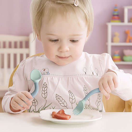 Bébé mange avec un couvert pour bébé​
