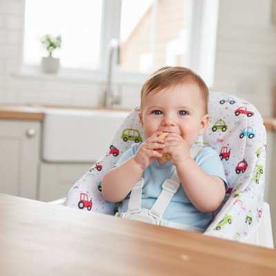 Bébé sur un coussin chaise haute avec motif voiture