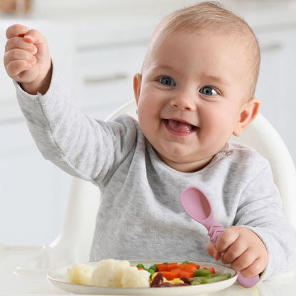 Couverts bébé rose dans la main du bébé 