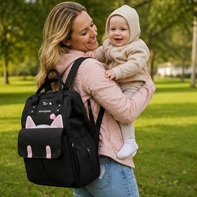 sac a langer couleur noir sur le dos du maman 