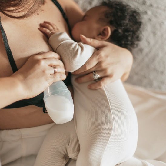 Tire lait manuel dans les main du maman avec un bébé 