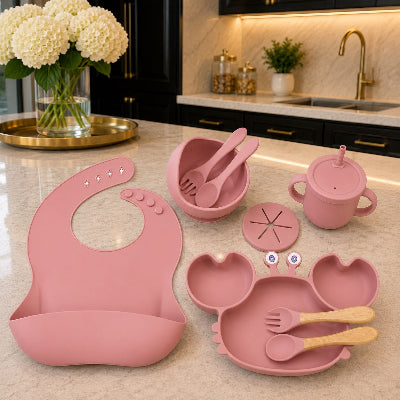Un coffret repas bébé rose sur table