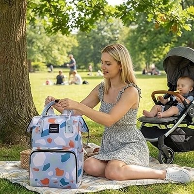 un sac a langer bebe sur un tapis dans un parc