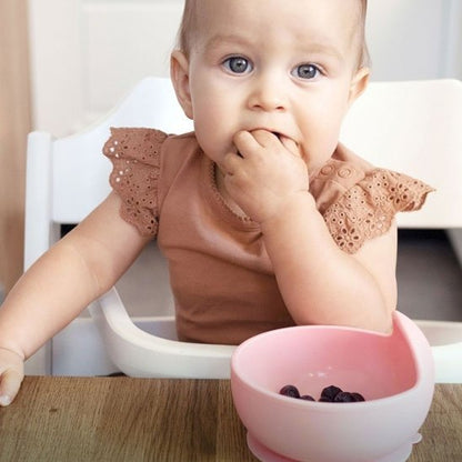 Une assiette bebe rose sur table